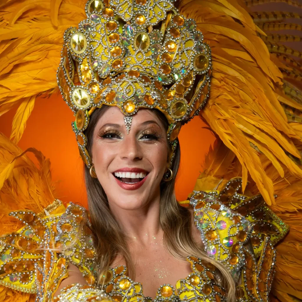 carnival stilt walker in golden costume with yellow feathers