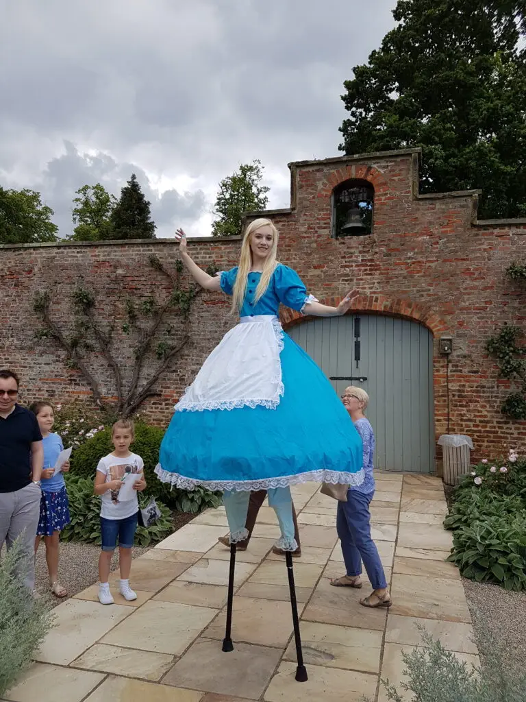 alice in wonderland stilt walker with children looking at her