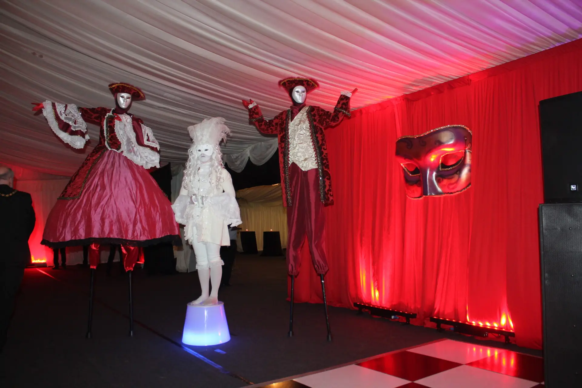 masquerade stilt walkers and human statue