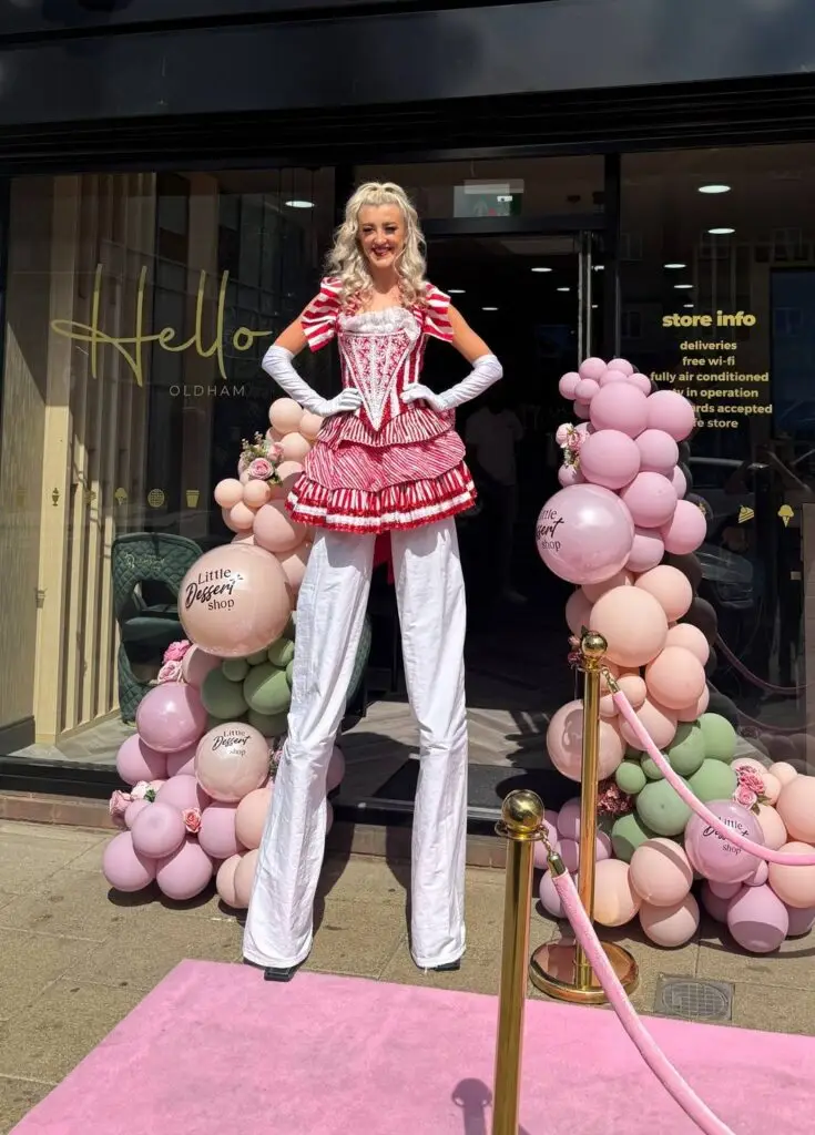 stilt walker at a shop opening with balloons