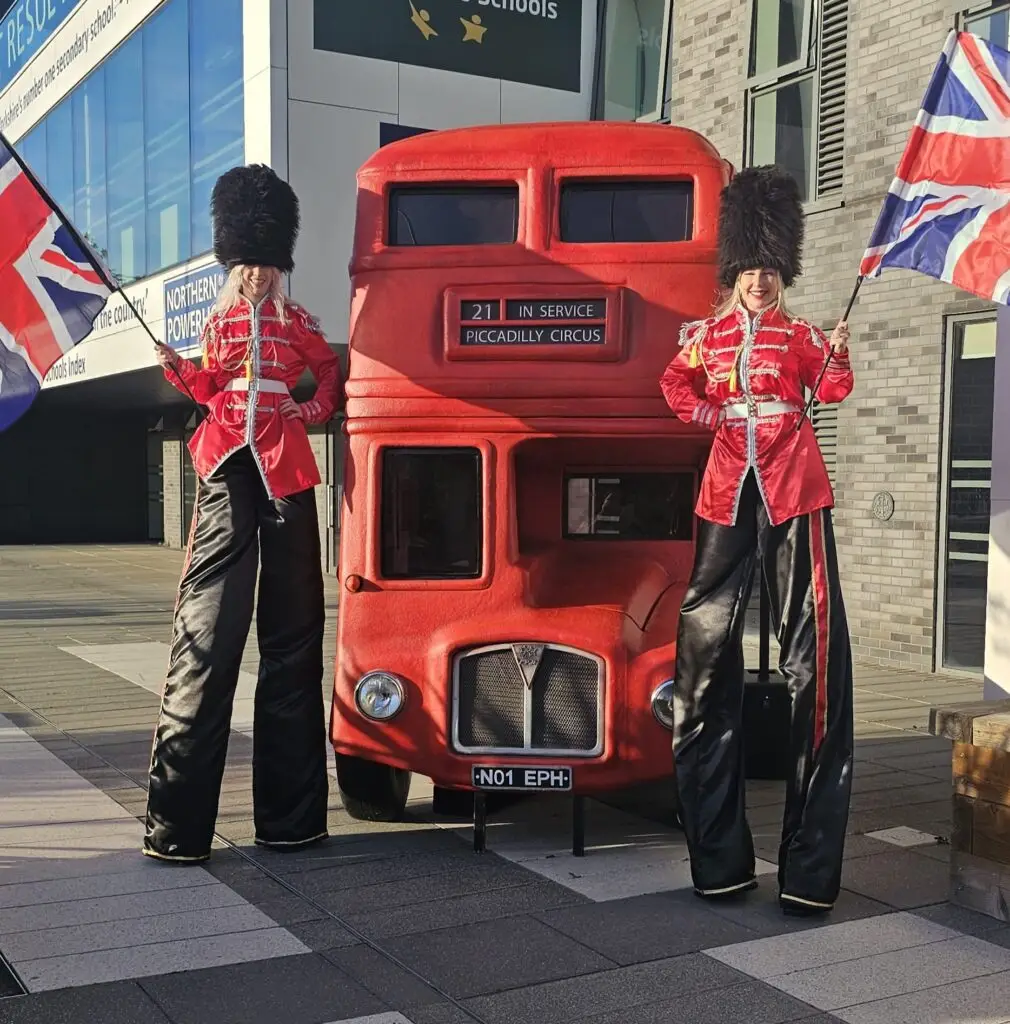 two kings guard stilt walker infront of a london bus